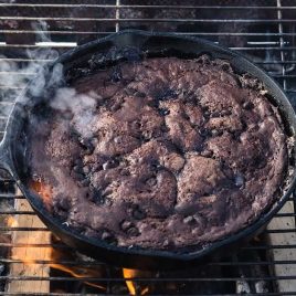 close up overhead shot of a skillet full of chocolate cake on a fire