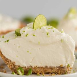 close up shot of a slice of Key Lime Pie garnished with lime on a plate