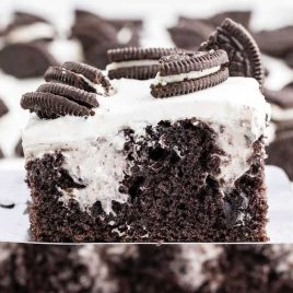 close up shot of a slice of cake topped with oreo cookies on a spatula