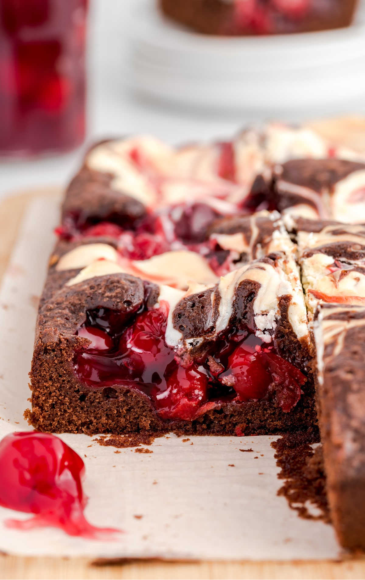 close up shot of cherry cheesecake brownies on a wooden board
