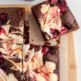 overhead shot of cherry cheesecake brownies on a wooden board