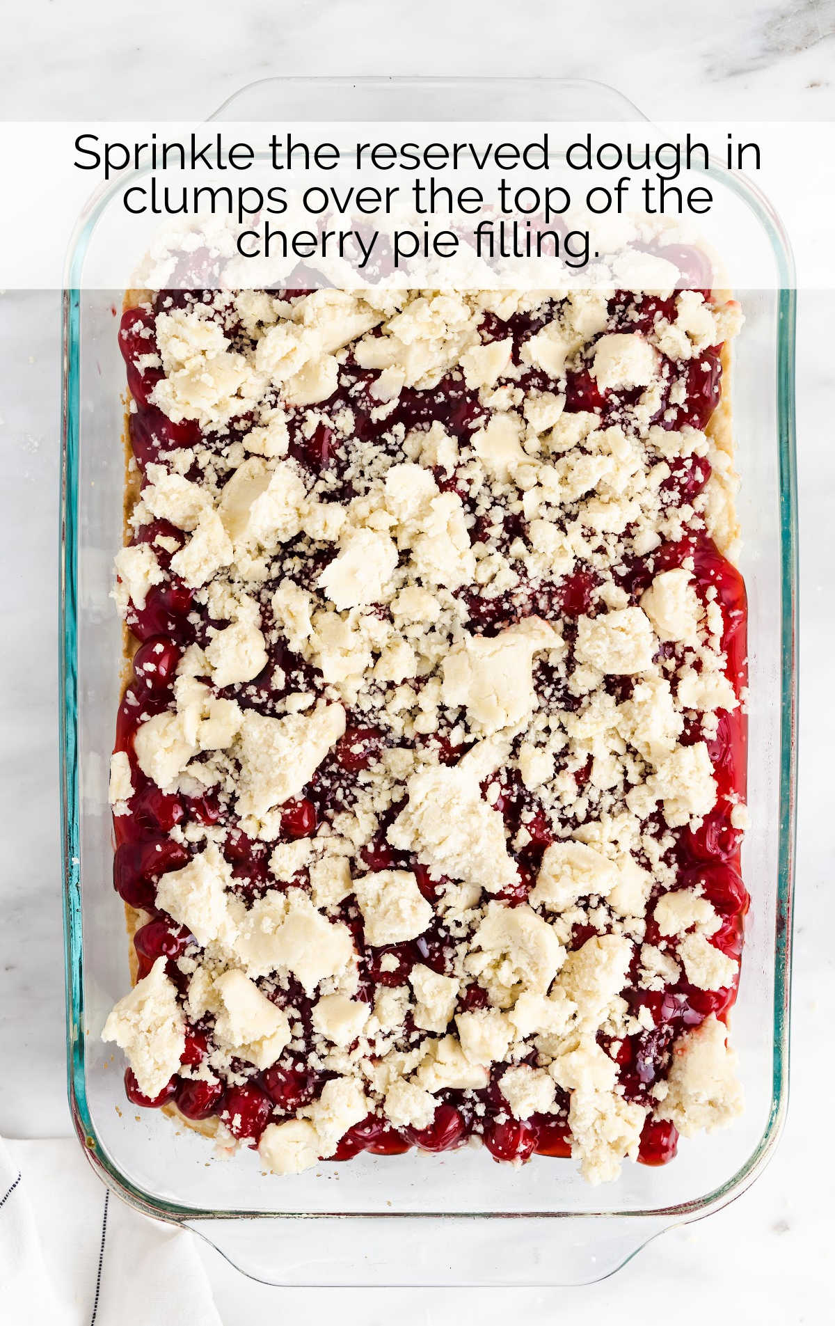 dough crumbled on top of the cherry pie filling