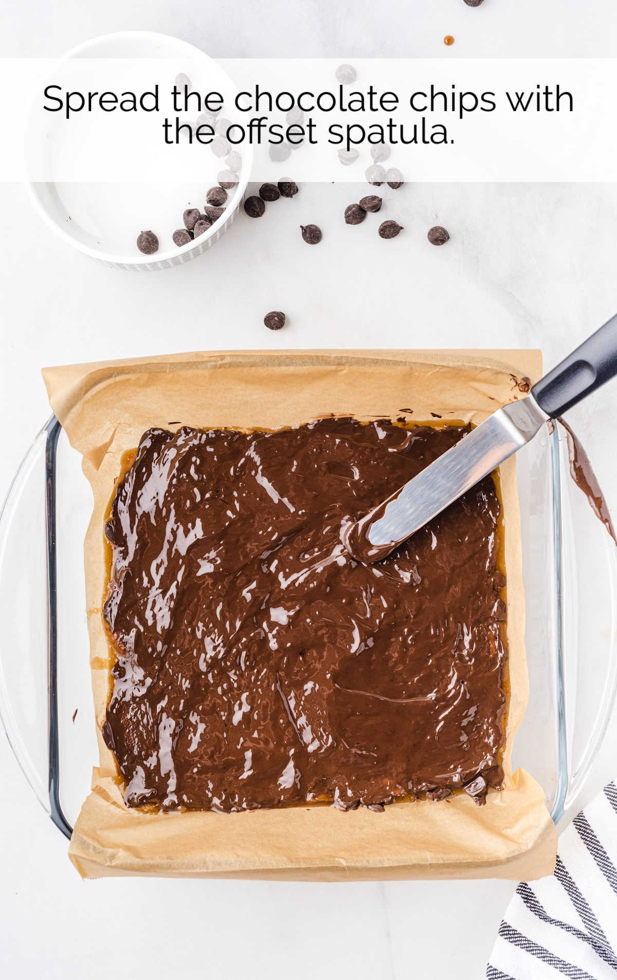 melted chocolate chips spread on top of the caramel sauce layer with a spatula