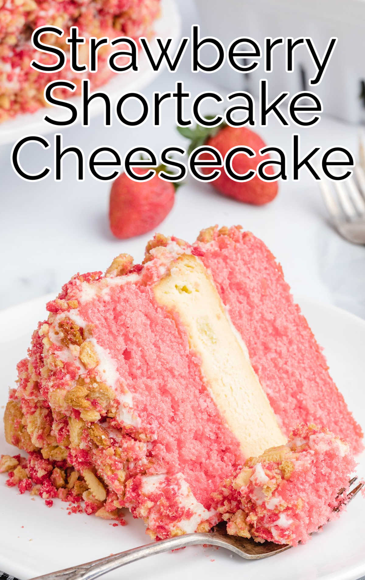 close up shot of a slice of Strawberry Shortcake Cheesecake on a plate with a piece taken out with a fork