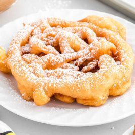 Funnel Cake topped with powdered sugar in a plate