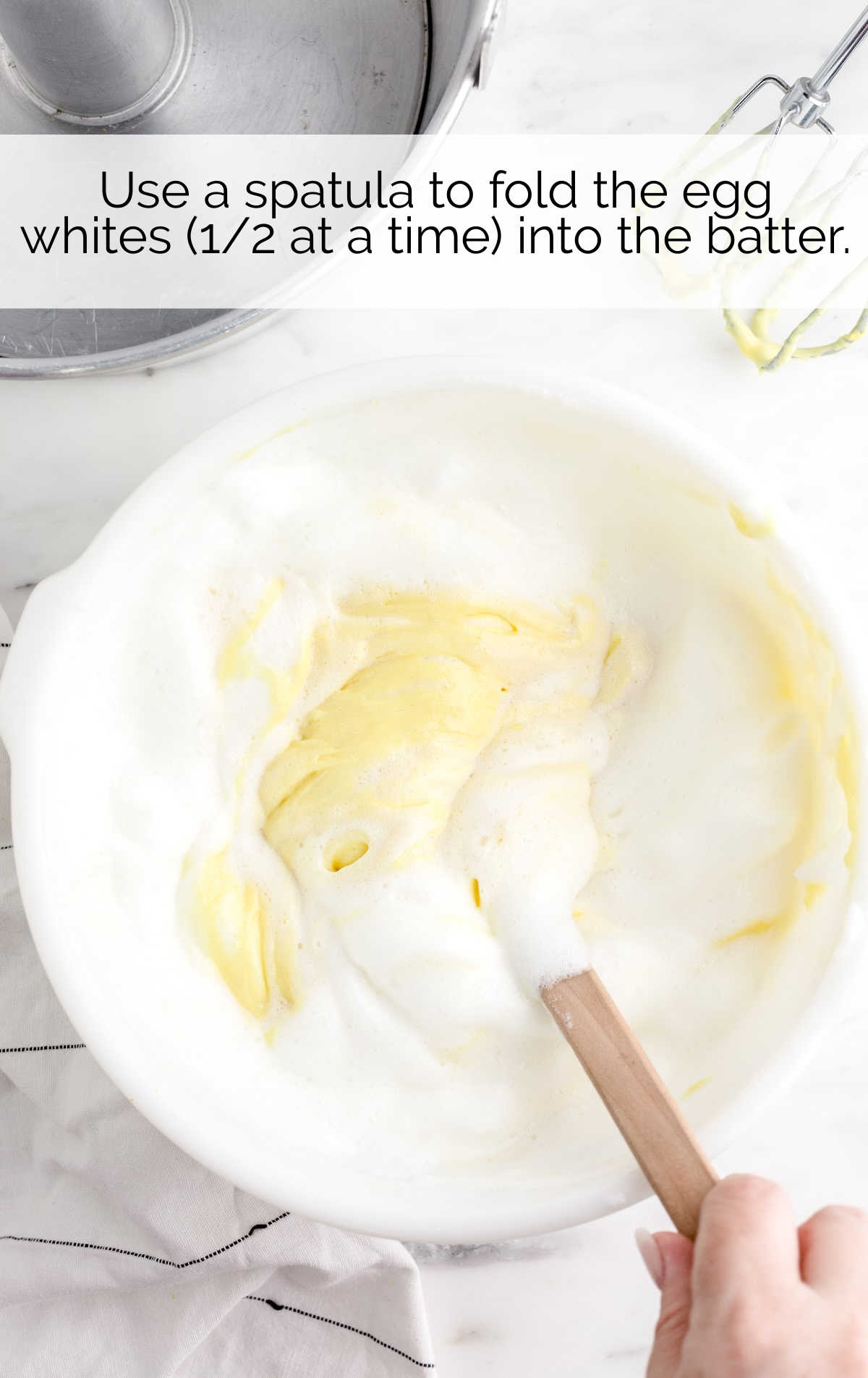 egg whites being folded into the cake batter in a bowl