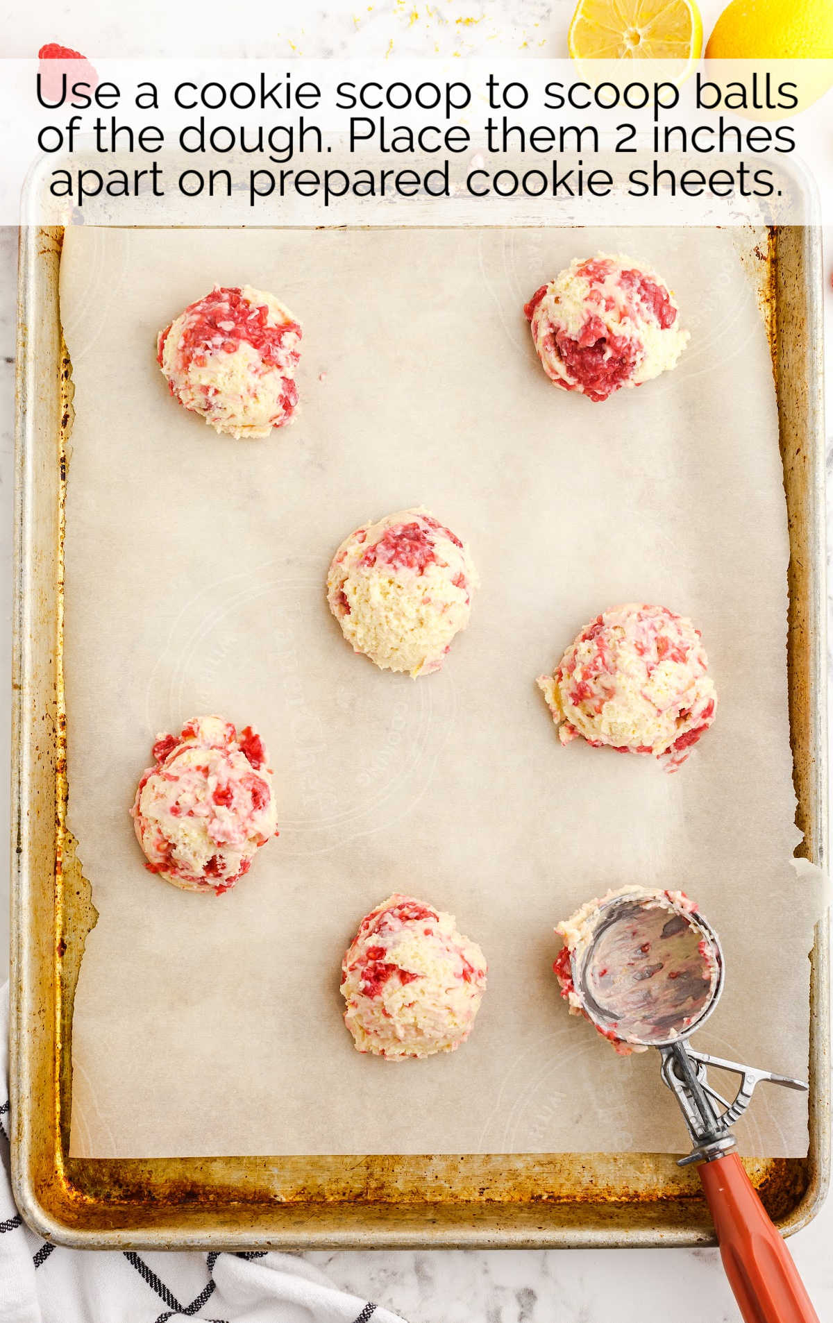 Lemon Raspberry Cookies dough placed in a baking dish using a cookie scooper