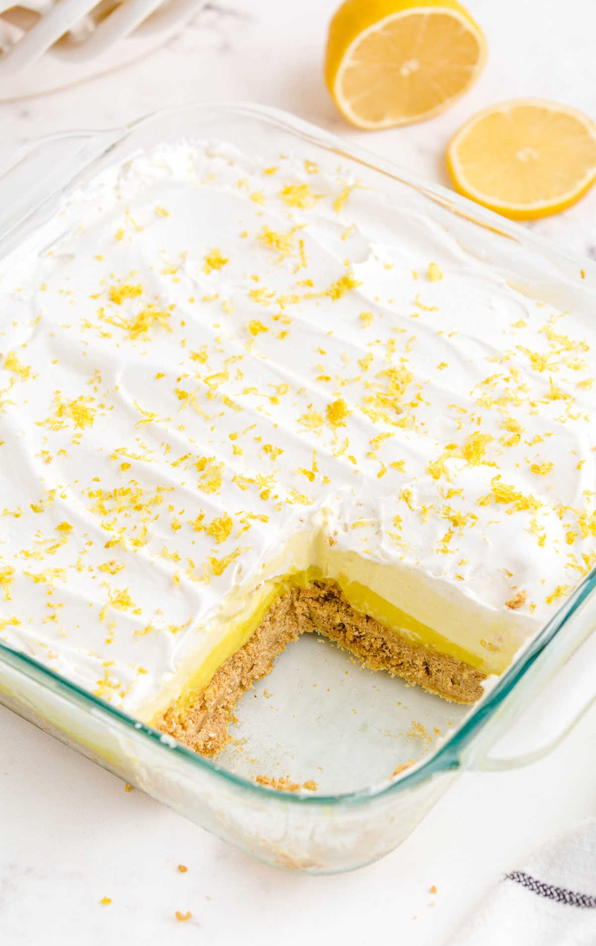 close up shot of lemon pie in a baking dish with a slice missing