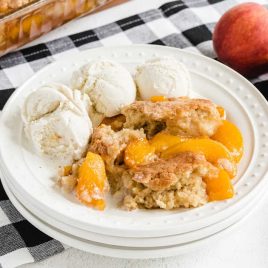 a slice of Peach Cobbler with ice cream in a plate