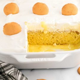 close up shot of Banana Pudding Cake in a baking dish with a slice missing