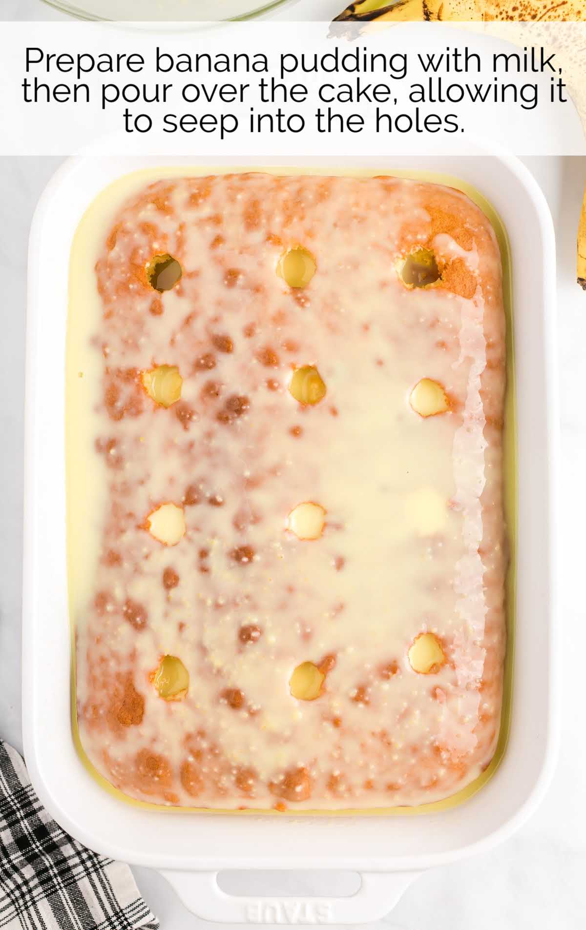 banana pudding with milk poured over the cake in a baking dish