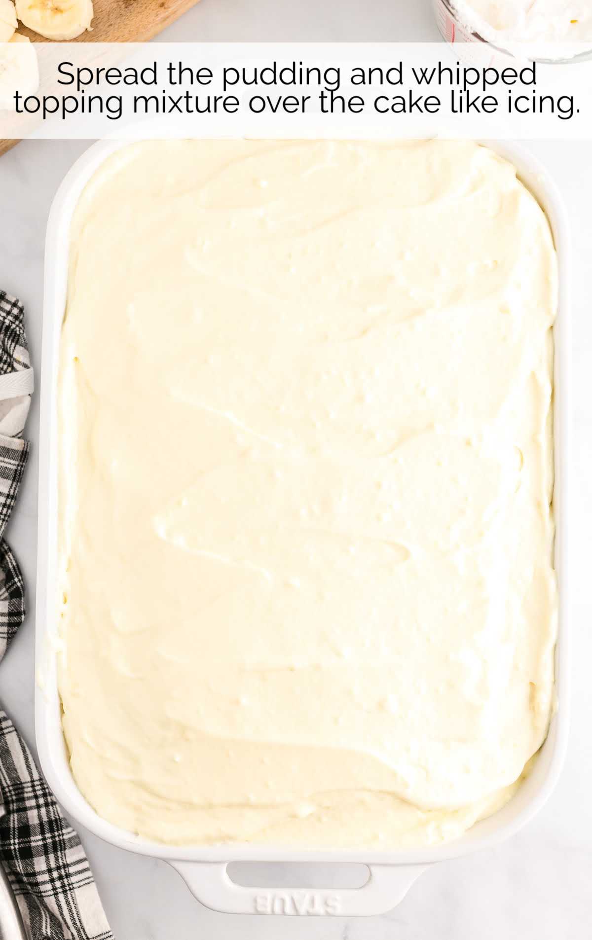 pudding and whipped topping mixture spread over the cake in a baking dish