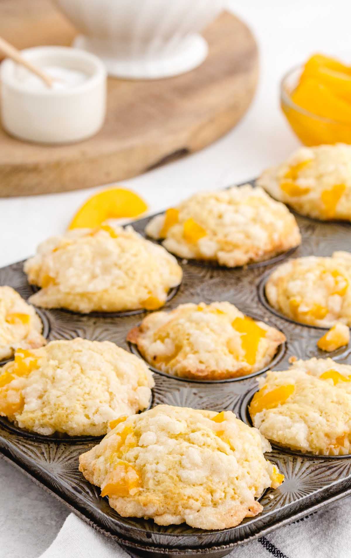 a bunch of Peach Cobbler Muffins in a cupcake pan