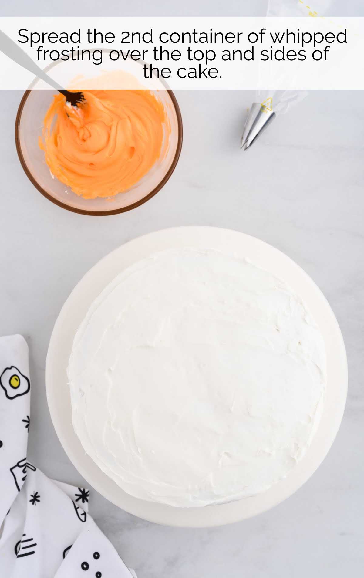 whipped cream frosting spread over the cake
