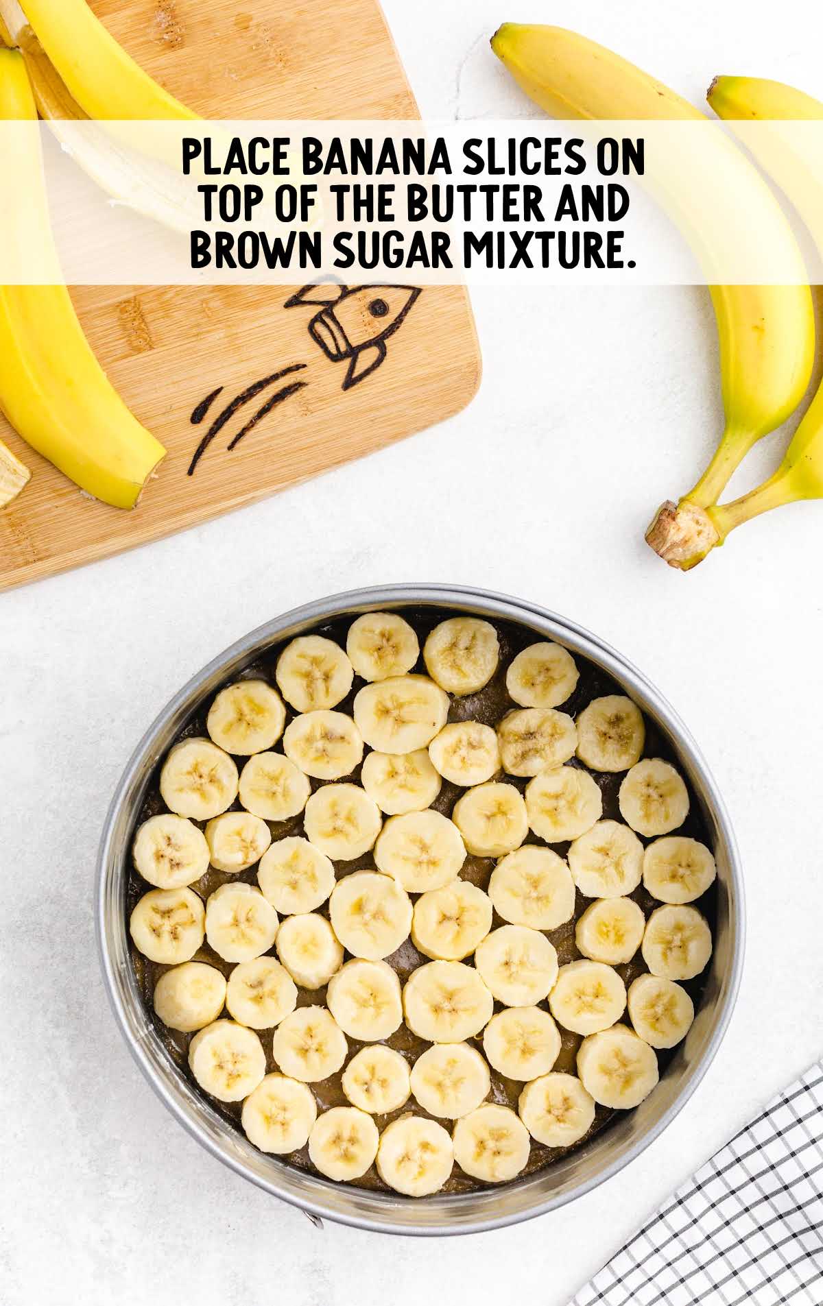 banana slices placed on top if the butter and brown sugar in a pan