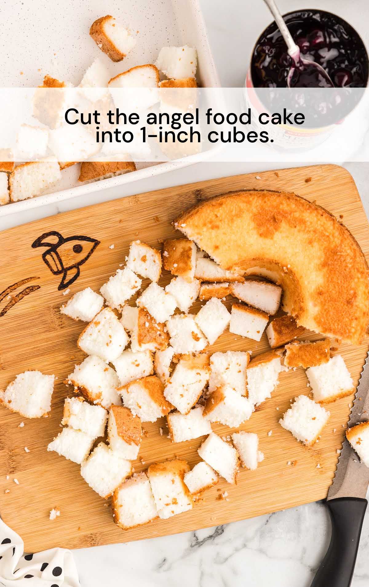 angel food cake cut into cubes on a wooden cutting board