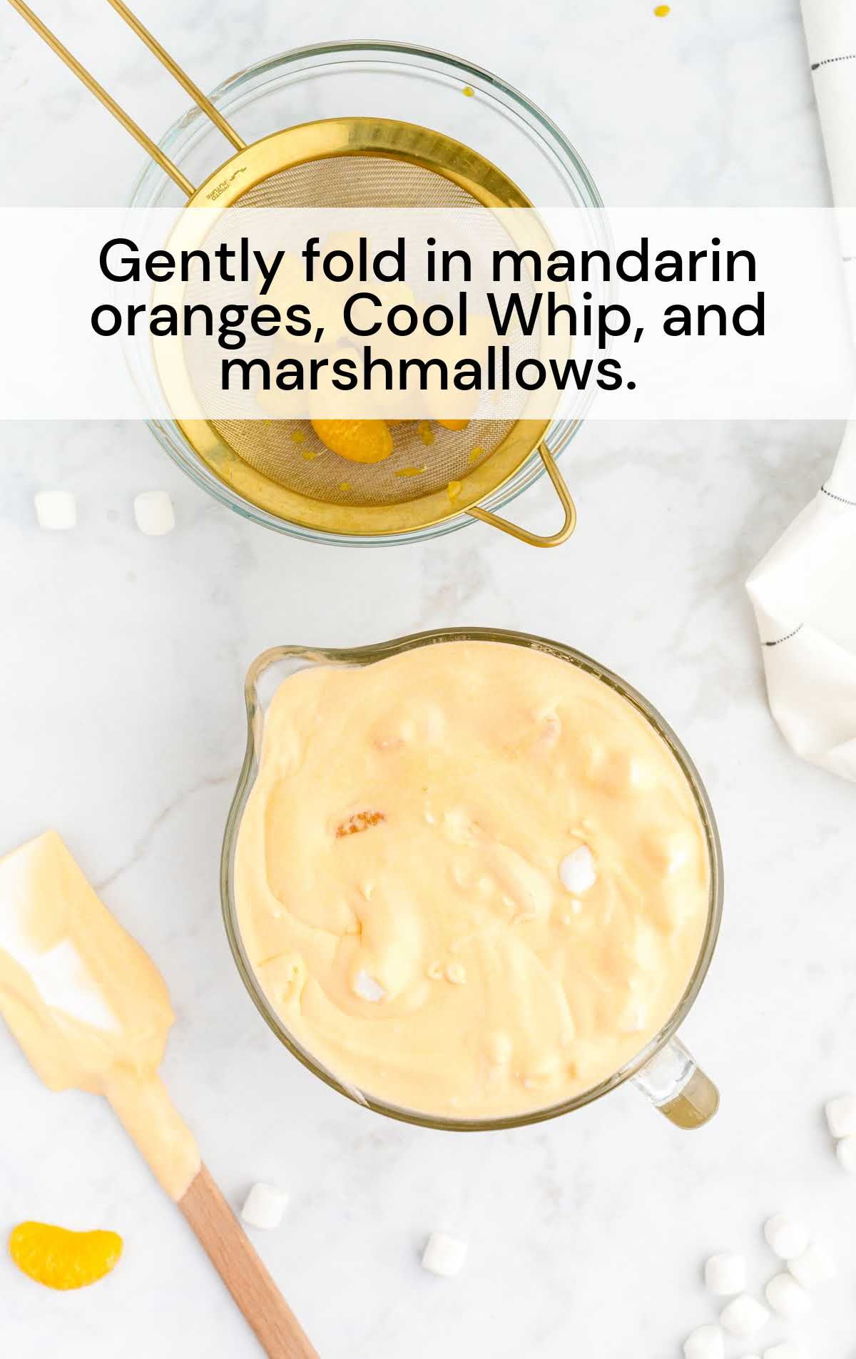mandarin oranges, cool whip, and marshmallows folded in a cup