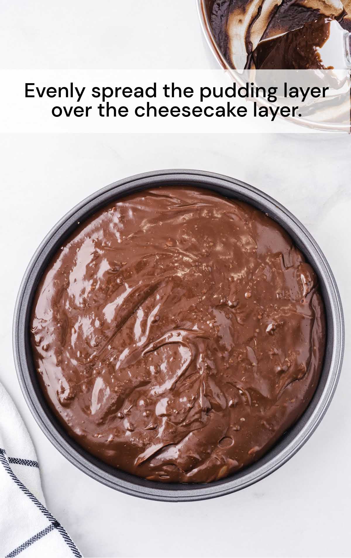 pudding layer spread over the cheesecake later in a baking dish