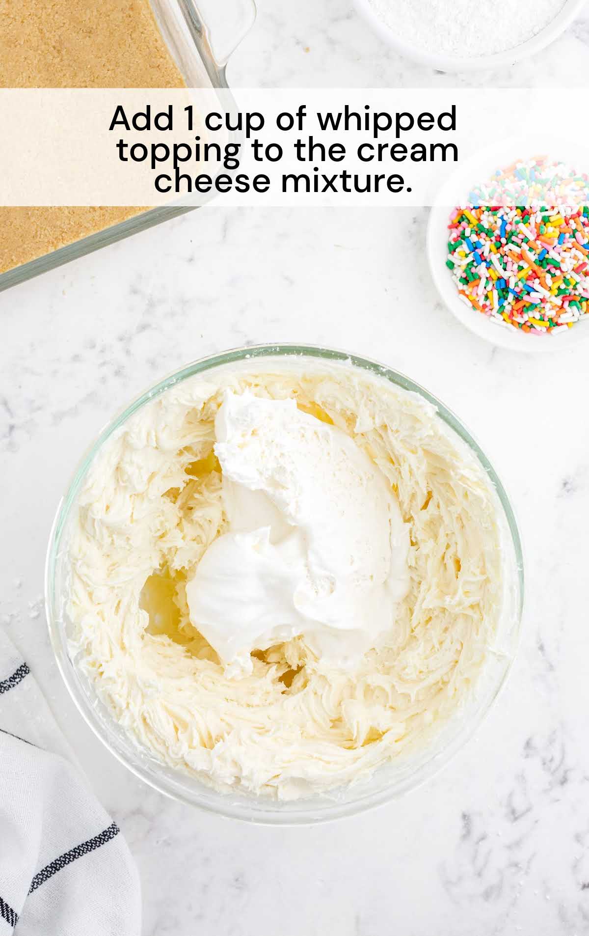 whipped topping added to the cream cheese in a bowl