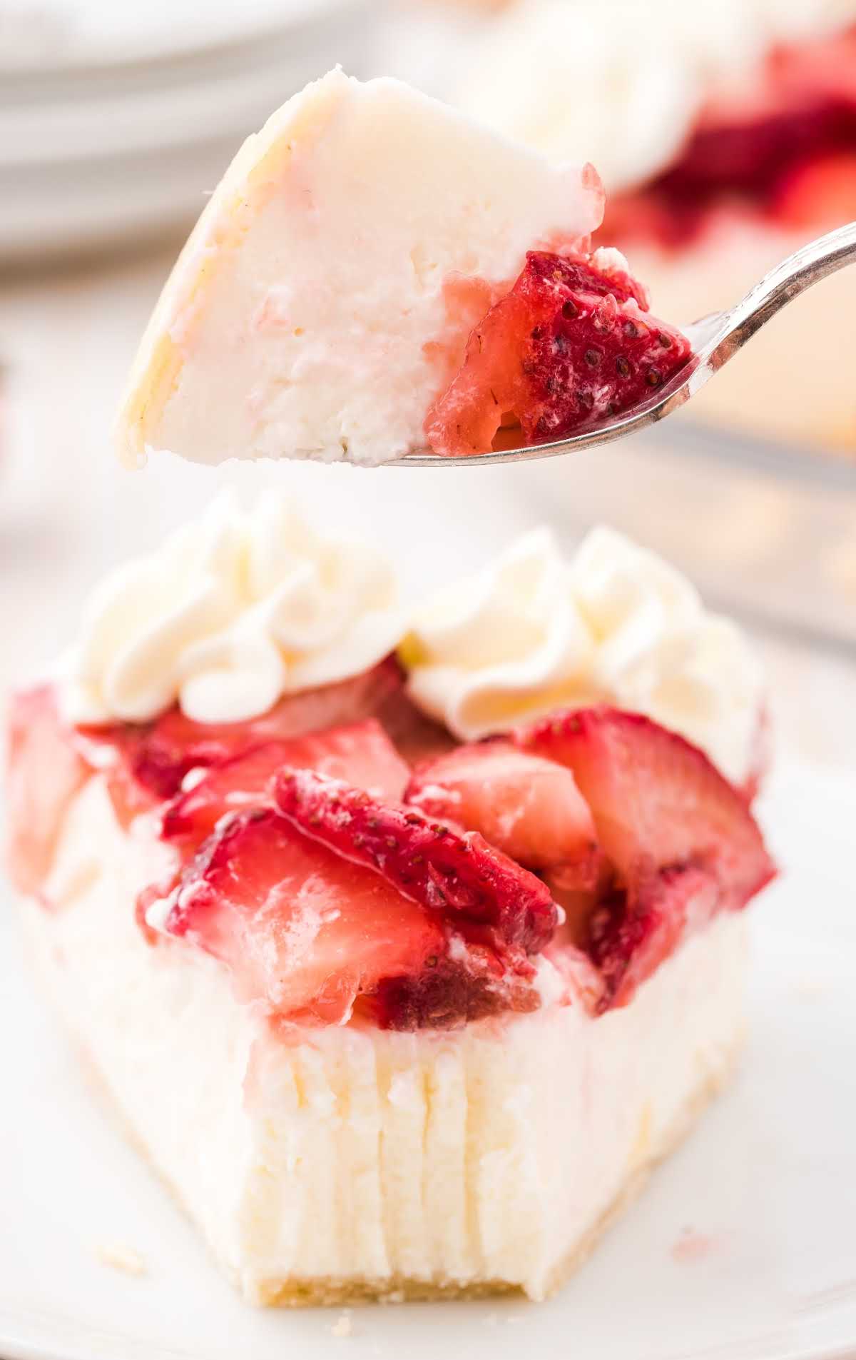 a close up shot of a slice of strawberry cream cheese pie with a fork getting a piece